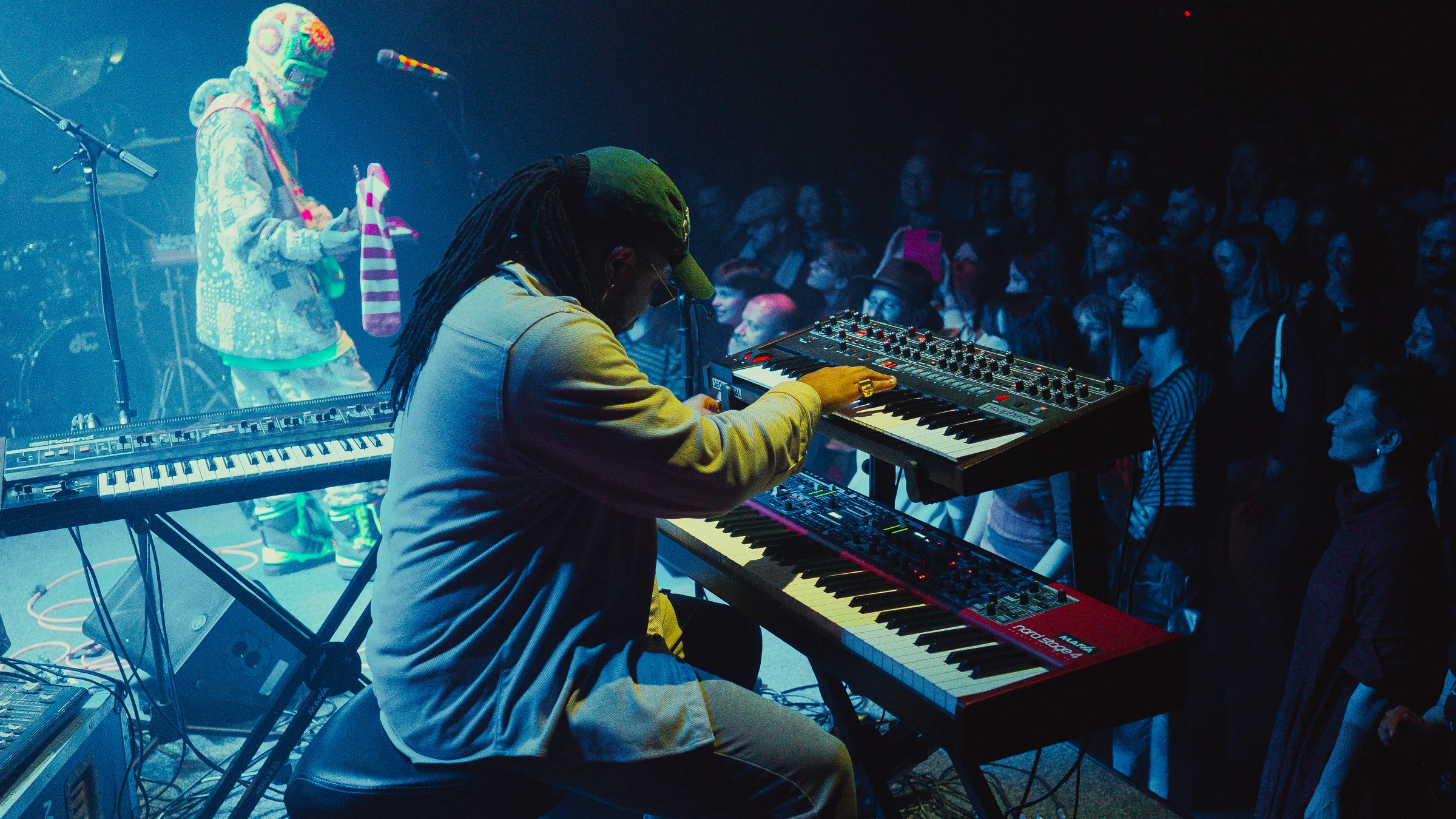Keyboard performance under blue and green stage lighting at Peti Kupe.