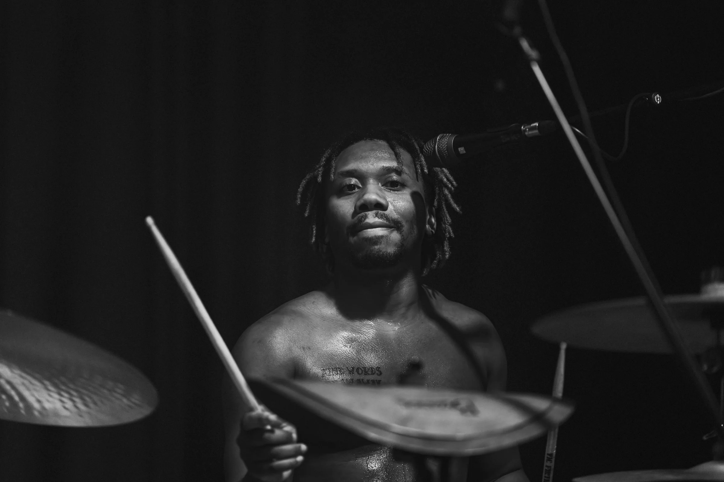 Black-and-white photograph of a drummer performing at Peti Kupe.