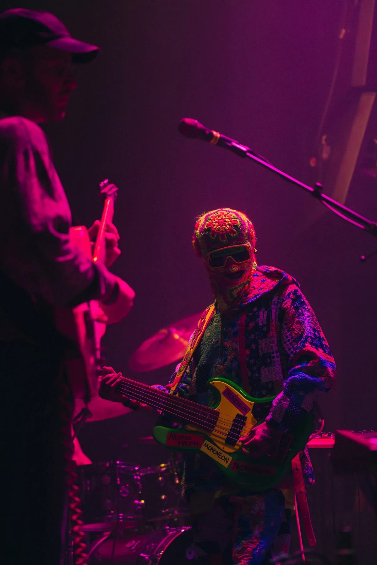 Bass player performing under magenta light at Peti Kupe.